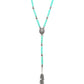 Close-up of turquoise beaded necklace with feather pendant