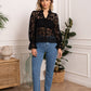 Woman in black lace top and jeans.