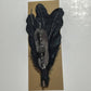 Black feather hair clip with beaded accent.