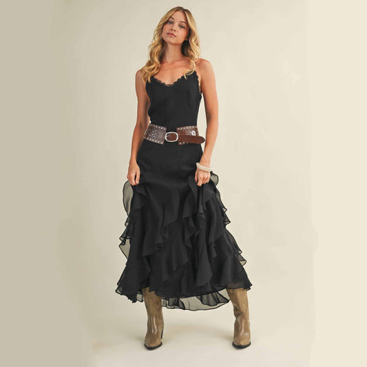 Woman in black ruffled dress with belt and boots