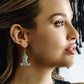 Woman wearing turquoise boot earrings
