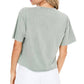 Woman in green shirt and white shorts.