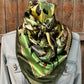 Green and yellow patterned silk scarf on denim jacket.