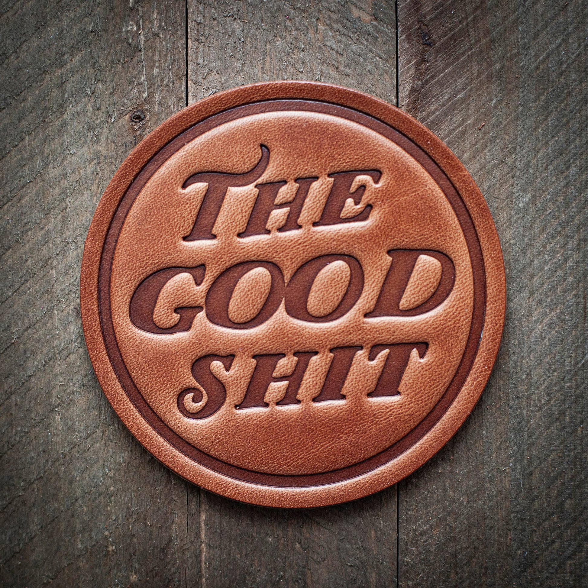 Leather coaster with THE GOOD SHIT text.