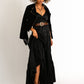 Woman in black dress and jacket with cowboy boots.