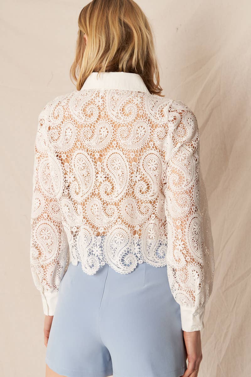 Woman in white lace shirt, blue pants.