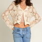 Woman in cream lace cardigan and jeans.
