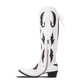 White and black Reverie cowboy boot on newsprint