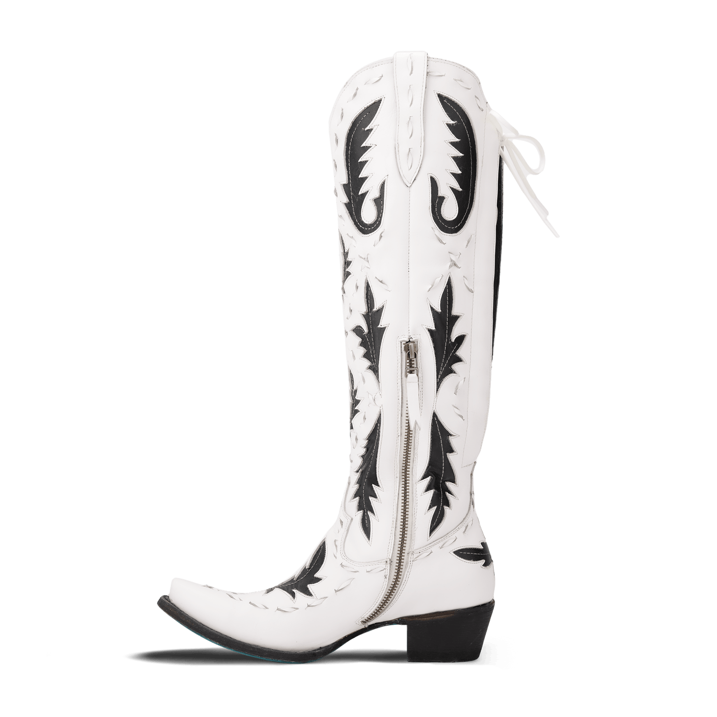 White and black Reverie cowboy boot on newsprint