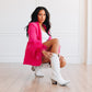Woman in pink blazer and white cowboy boots