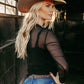 Blonde woman in cowboy hat and mesh top