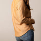 Woman in tan button-up shirt and jeans