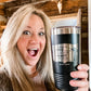 Woman holding a black tumbler with text.