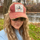 Woman wearing sunglasses and a red cap.
