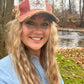 Woman wearing a red cap, smiling, outdoors.