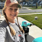 Woman in hat and braids, scooter in background.