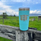Blue tumbler on wooden fence.