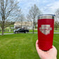 Hand holding a red tumbler with text.