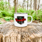 White mug with text on a tree stump.